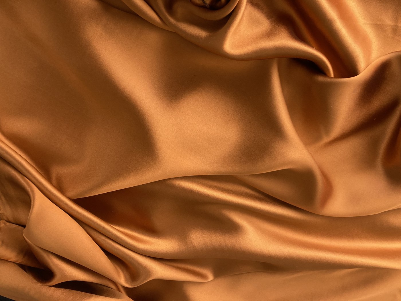 Seta color rame drappeggiata, con riflessi luminosi